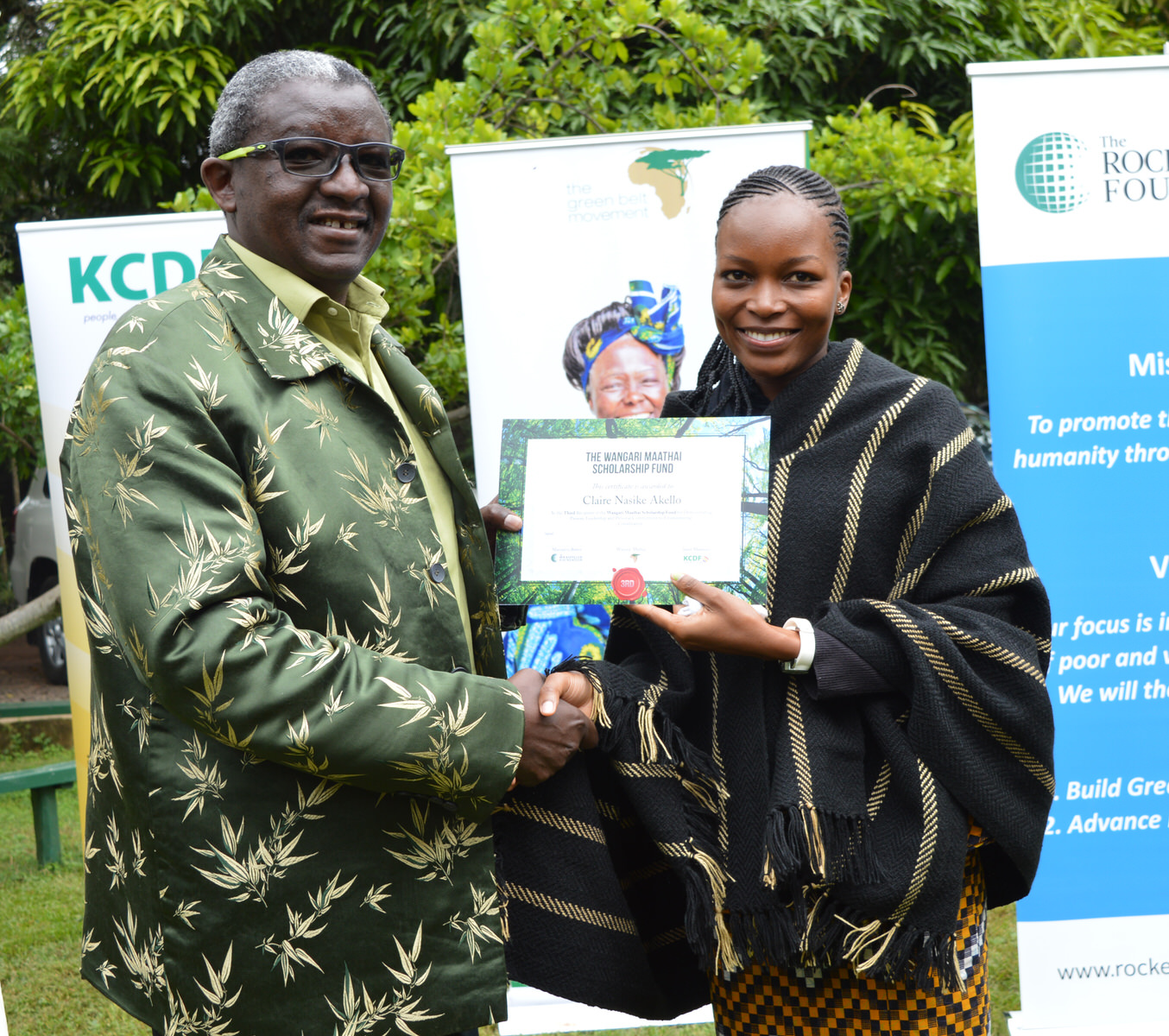 Claire Nasike Akello receives her certificate from Dr. Isaac Kalua, founder of Green Africa Foundation